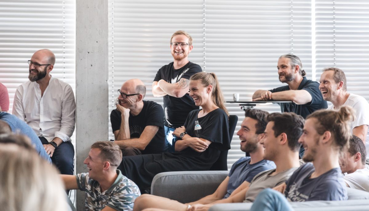 People in a design studio laughing during a presentation