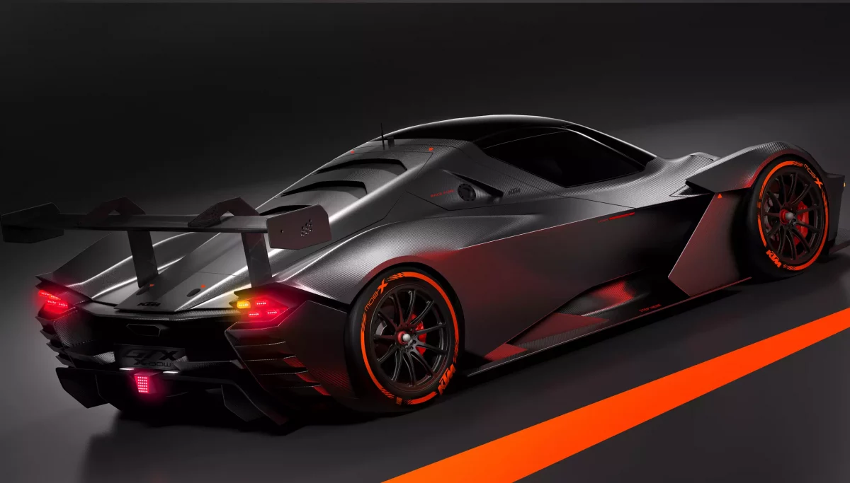 KTM X-BOW GTX with lights on, side rear view with orange strip on road