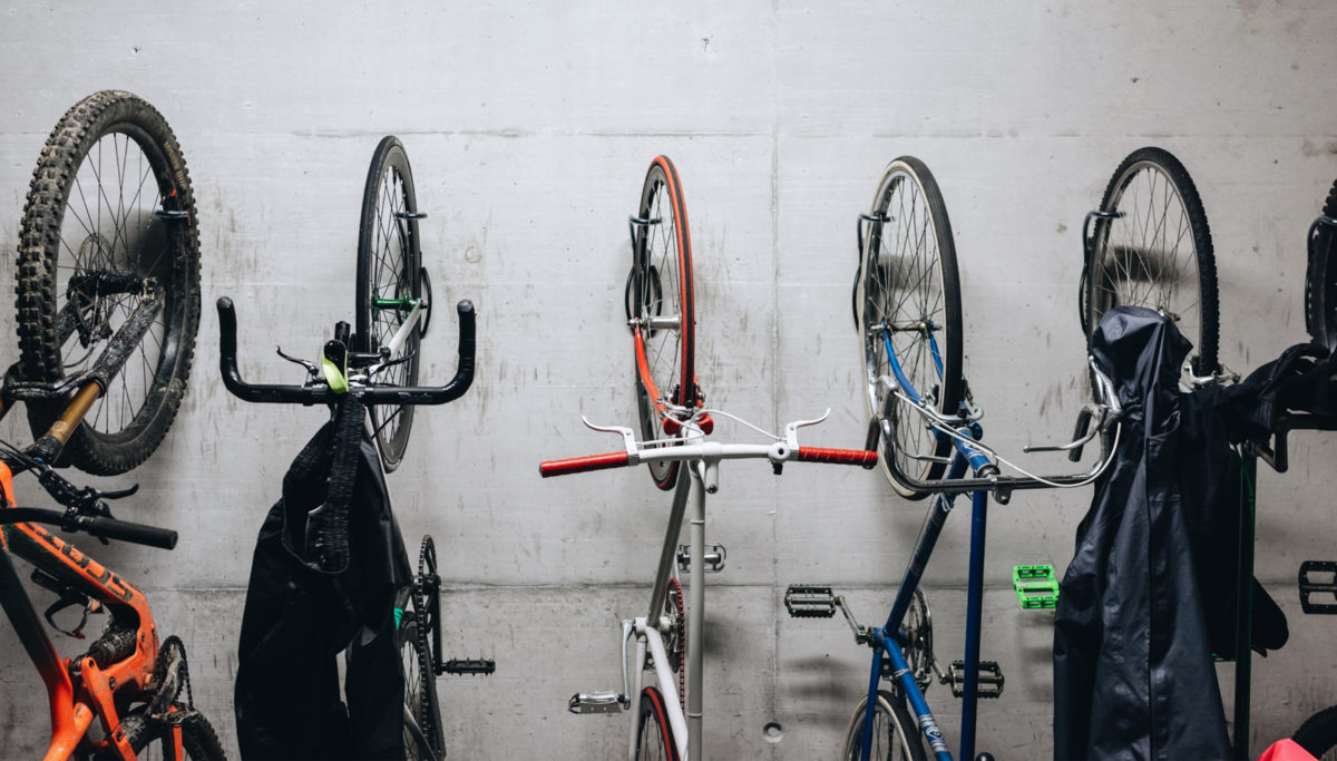 Bicycles hanging by their front wheel in garage by bike racks