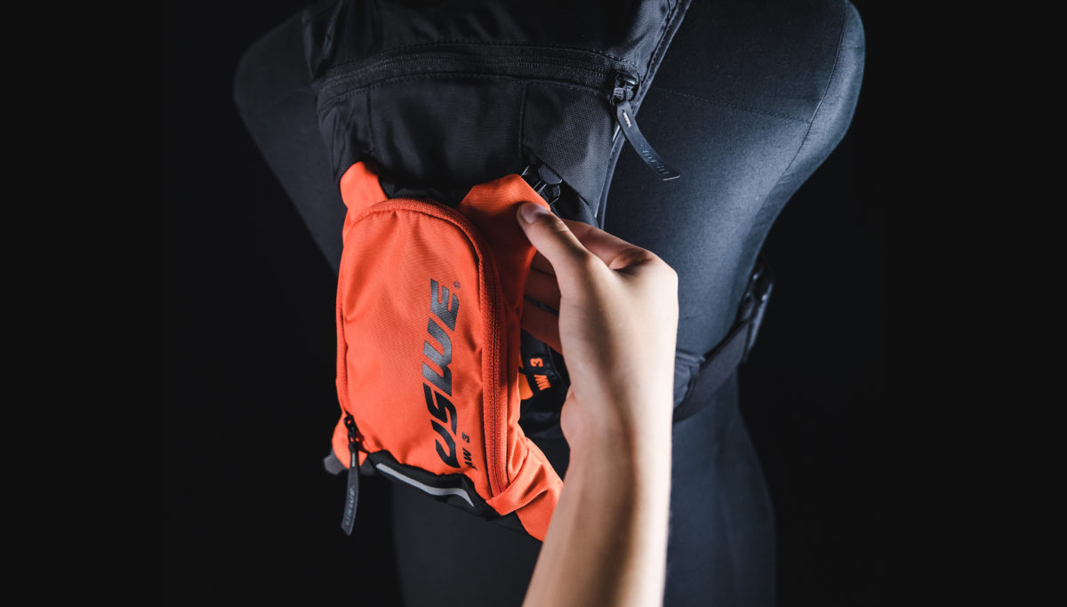 Orange and Black USWE Hydration Backpack being clipped in on Mannequin