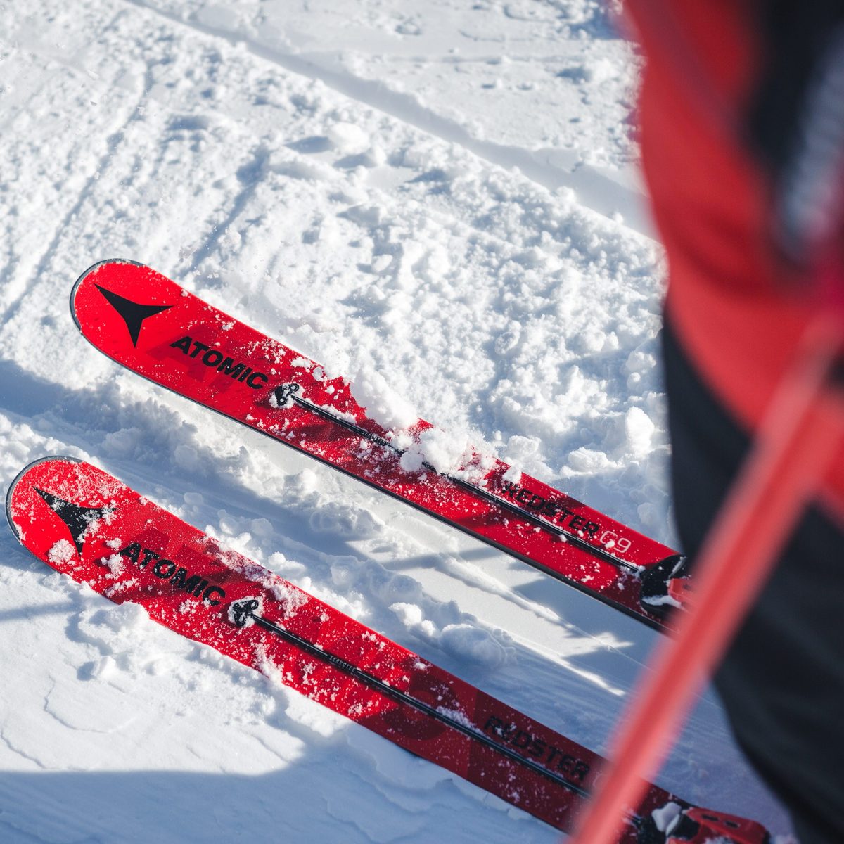 Top down view of Atomic Redster skis with Atomic logo on the snow