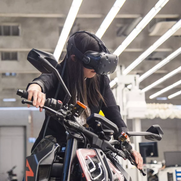 KISKA connected products and services lead on a motorcycle and wearing VR goggles, testing experience prototype of app and instrument