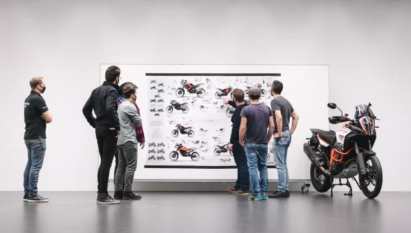 KISKA Employees reviewing Motorcycle Designs on wall - Landscape Crop