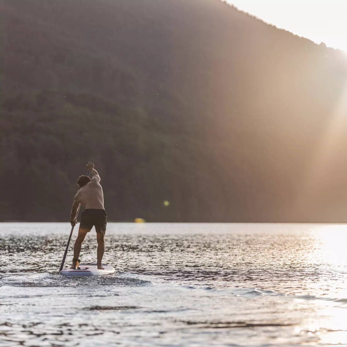 Matteo Cerutti a KISKA product management consultant paddle boarding on an Austrian alpine lake after work