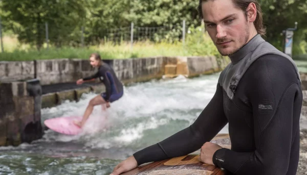 KISKA content designer waxing KISKA surfboard with person river surfing on Salzburg Almkanal